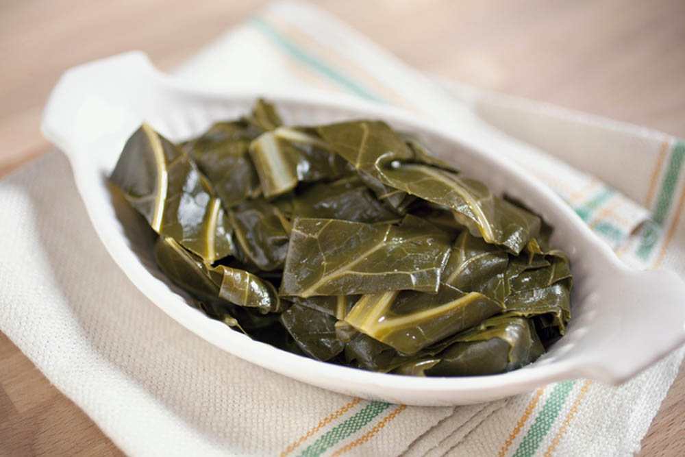 Plato de hojas de col cocidas servidas en una fuente blanca