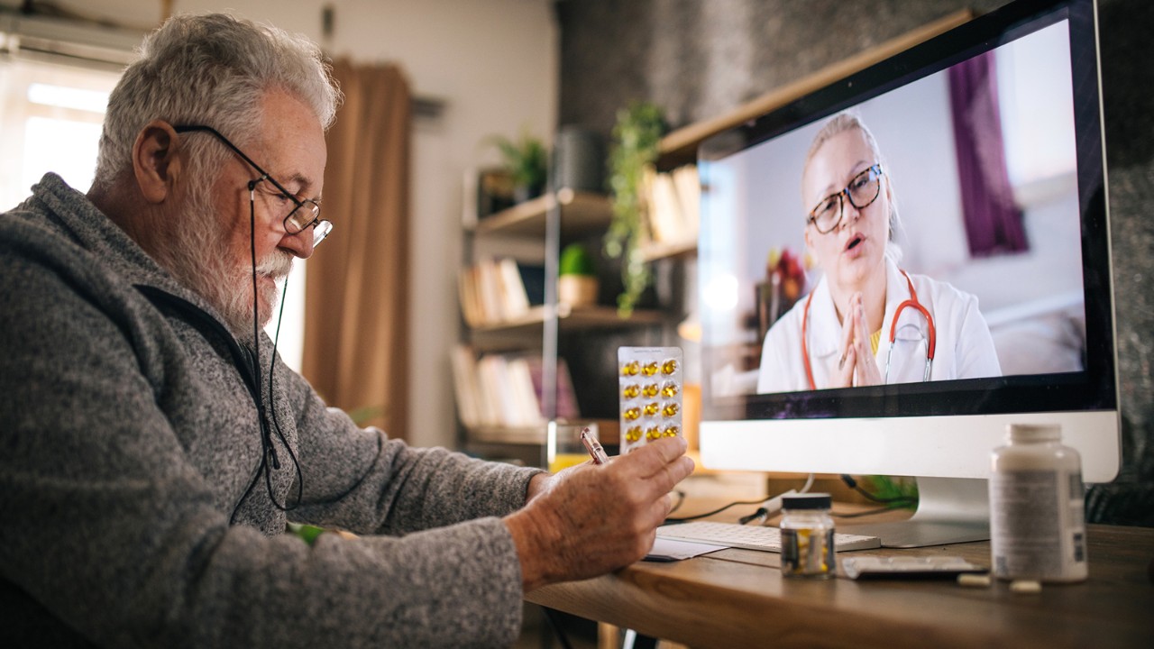 Man reviewing medication on a virtual visit with a doctor