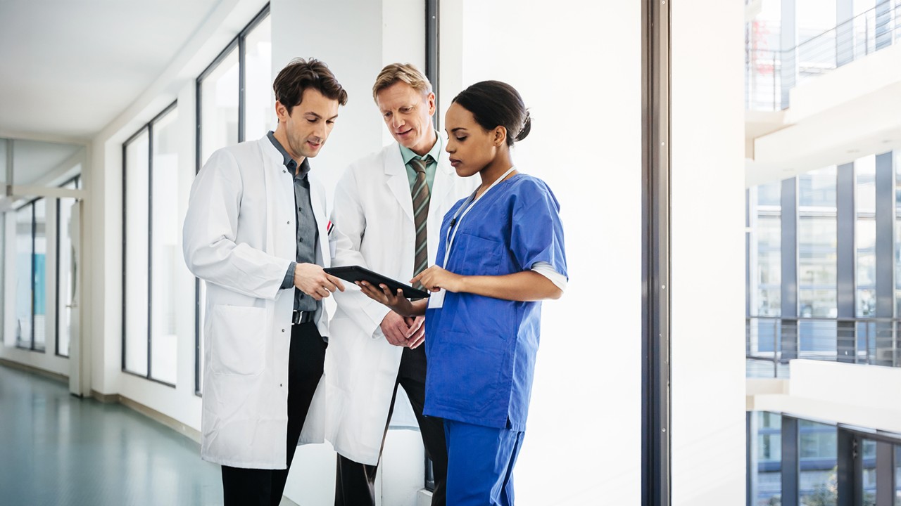 Doctors reviewing a tablet in a hallway