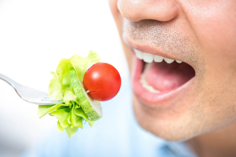 Joven comiendo una ensalada saludable, primer plano